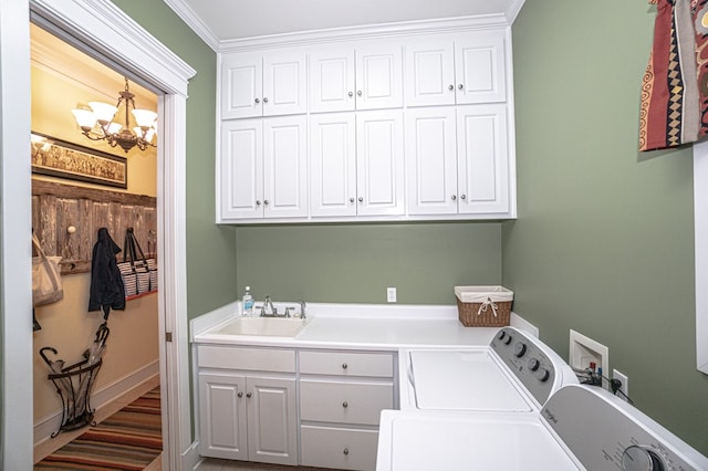 laundry room featuring cabinets, ornamental molding, sink, separate washer and dryer, and a notable chandelier