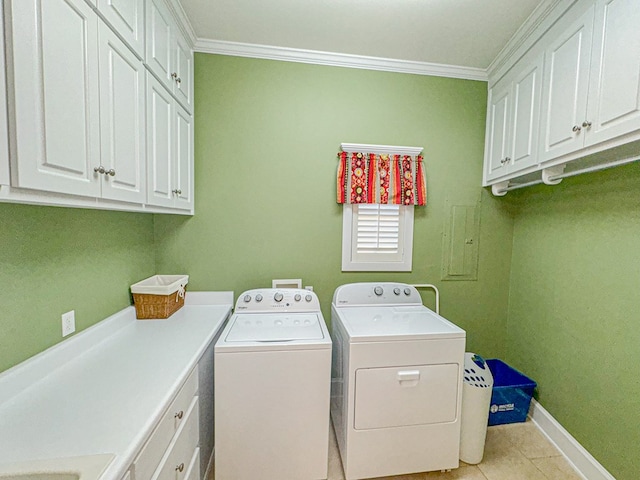 washroom featuring cabinets, washing machine and dryer, light tile patterned floors, and crown molding