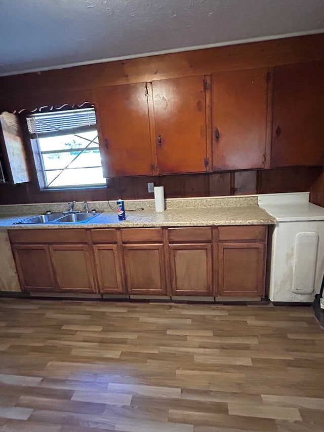 kitchen with light hardwood / wood-style floors, sink, and washer / clothes dryer