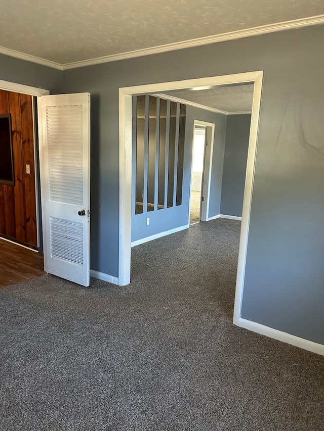 spare room with a textured ceiling, carpet floors, and crown molding