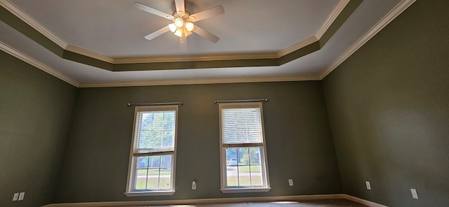 carpeted empty room with ornamental molding, a raised ceiling, and ceiling fan