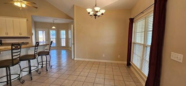 kitchen featuring a breakfast bar, ceiling fan with notable chandelier, white cabinetry, lofted ceiling, and hanging light fixtures