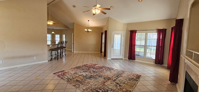 tiled foyer with ceiling fan with notable chandelier and high vaulted ceiling