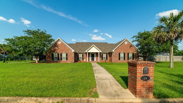 ranch-style house with a front lawn, fence, and brick siding