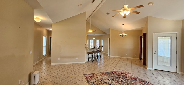 tiled entryway with ceiling fan with notable chandelier, high vaulted ceiling, and a healthy amount of sunlight