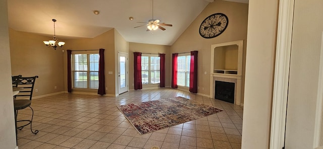 unfurnished living room with ceiling fan with notable chandelier, high vaulted ceiling, and light tile patterned flooring