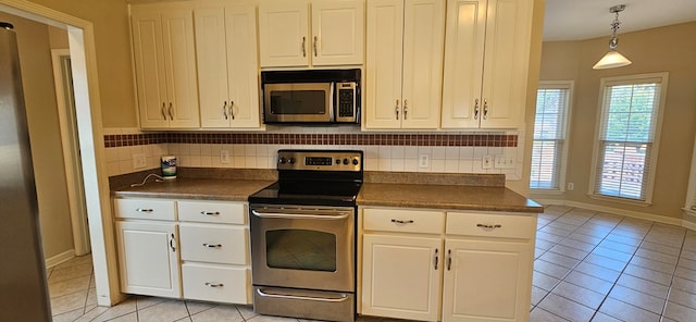 kitchen with white cabinetry, hanging light fixtures, light tile patterned floors, stainless steel appliances, and backsplash