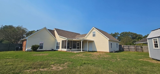 rear view of property with a lawn and a sunroom