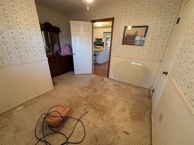 unfurnished bedroom featuring carpet flooring and crown molding