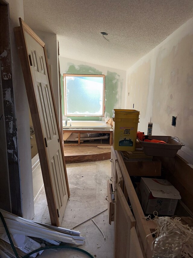 miscellaneous room with a workshop area and a textured ceiling