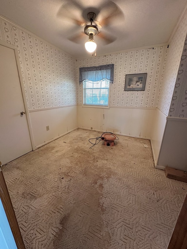 empty room with a textured ceiling, light colored carpet, and ceiling fan