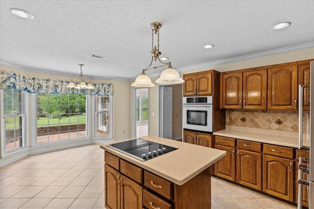 105 Christen Ln, Dothan, AL 36305 - kitchen with white oven, light countertops, tasteful backsplash, brown cabinets, and black electric cooktop