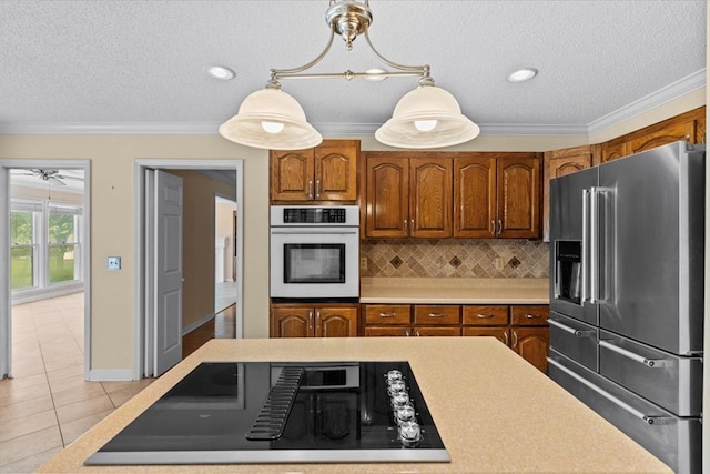 105 Christen Ln, Dothan, AL 36305 - kitchen featuring decorative backsplash, oven, ornamental molding, stovetop with downdraft, and high end fridge