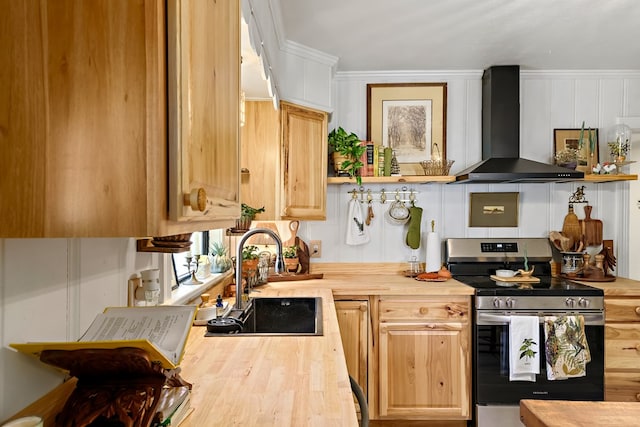 kitchen with a sink, wall chimney exhaust hood, wood counters, and stainless steel electric stove