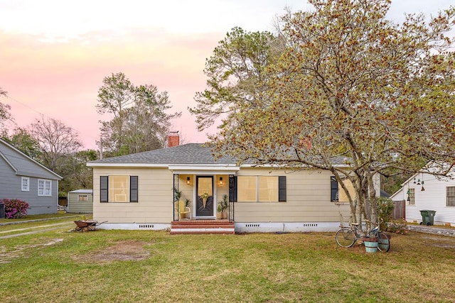 view of front of home with crawl space, roof with shingles, a chimney, and a front yard