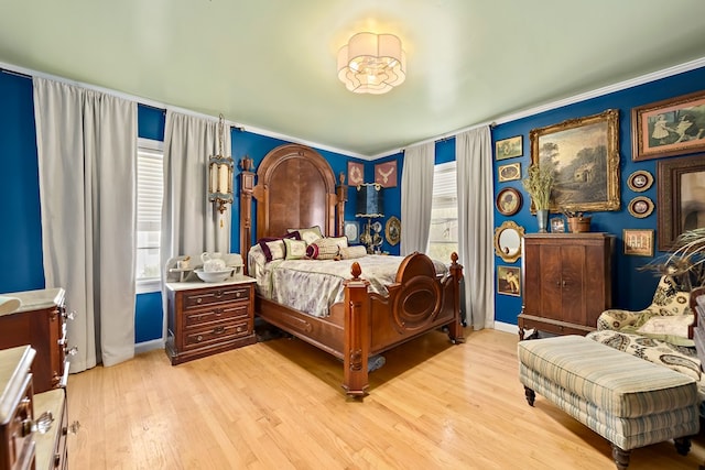 bedroom featuring light wood-type flooring, multiple windows, and baseboards