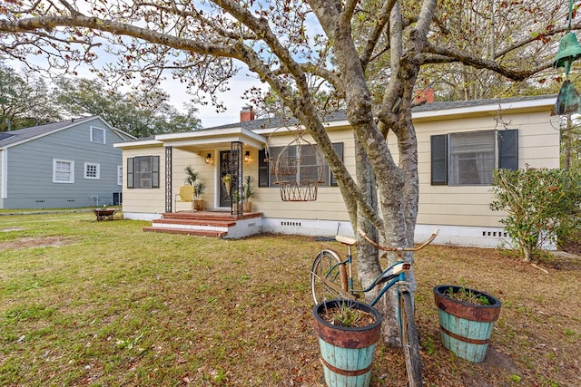 view of front of property with a front lawn, crawl space, and a chimney