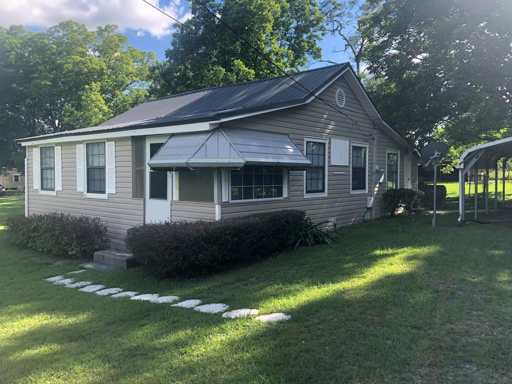 view of home's exterior featuring a yard and a carport