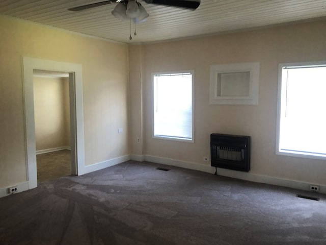 interior space with heating unit, a wealth of natural light, and ceiling fan