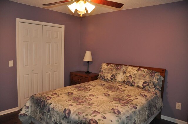 bedroom featuring dark wood-type flooring, ceiling fan, and a closet