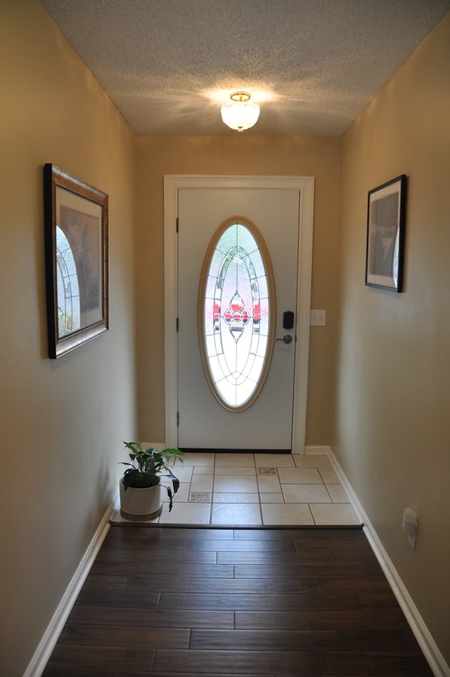 doorway with dark hardwood / wood-style floors and a textured ceiling