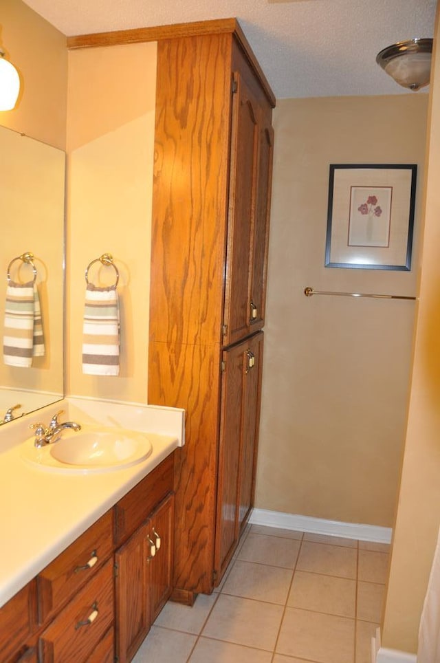 bathroom with tile patterned flooring, vanity, and a textured ceiling