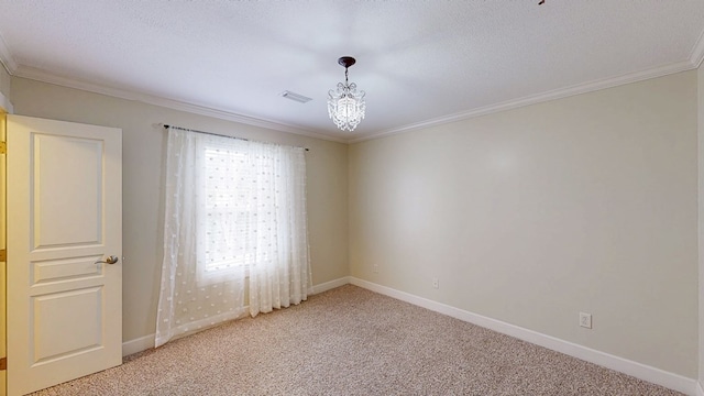 carpeted spare room with ornamental molding, a textured ceiling, and an inviting chandelier