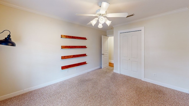 unfurnished bedroom with crown molding, light colored carpet, ceiling fan, and a closet