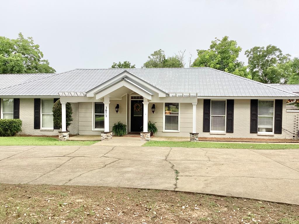 3071 Trawick Rd, Dothan, AL 36305 - view of front of home with a metal roof, brick siding, and concrete driveway