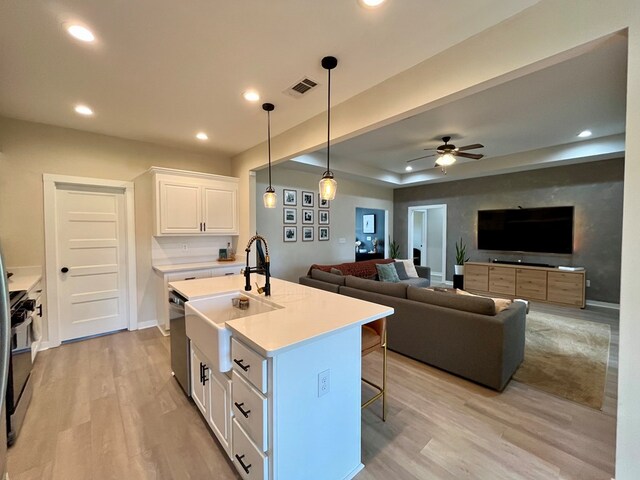 212 Neenan Dr, Enterprise, AL 36330 - kitchen featuring light wood-style flooring, light countertops, white cabinetry, gas range oven, and a kitchen bar
