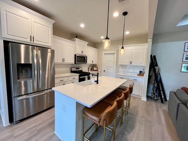 212 Neenan Dr, Enterprise, AL 36330 - kitchen with stainless steel appliances, tasteful backsplash, light wood finished floors, white cabinetry, and recessed lighting