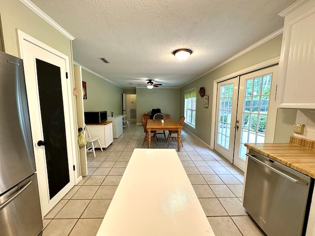 1317 Cambridge Rd, Dothan, AL 36305 - dining area featuring french doors, light tile patterned flooring, a ceiling fan, crown molding, and a textured ceiling