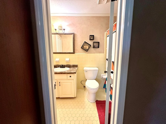 1317 Cambridge Rd, Dothan, AL 36305 - full bath with toilet, vanity, wainscoting, a textured ceiling, and tile walls