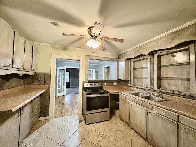 kitchen with stainless steel range with electric stovetop, ceiling fan, crown molding, sink, and light tile patterned floors