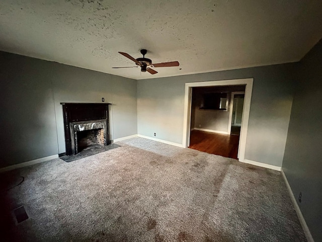 unfurnished living room featuring a textured ceiling, dark carpet, and ceiling fan