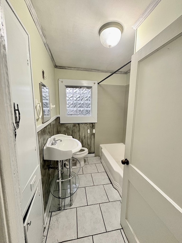 bathroom featuring toilet, tile patterned floors, ornamental molding, and sink