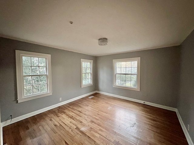 unfurnished room with hardwood / wood-style flooring