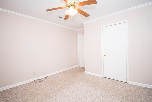 spare room featuring baseboards, visible vents, light colored carpet, ceiling fan, and crown molding