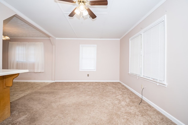 carpeted empty room featuring plenty of natural light, baseboards, ornamental molding, and ceiling fan