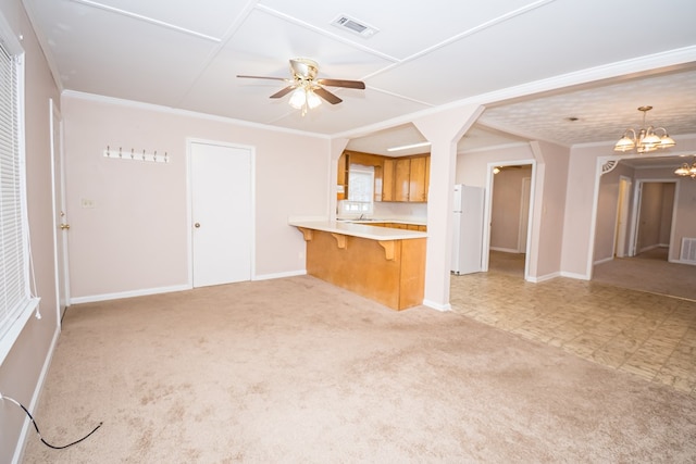 kitchen featuring light carpet, visible vents, crown molding, and ceiling fan with notable chandelier