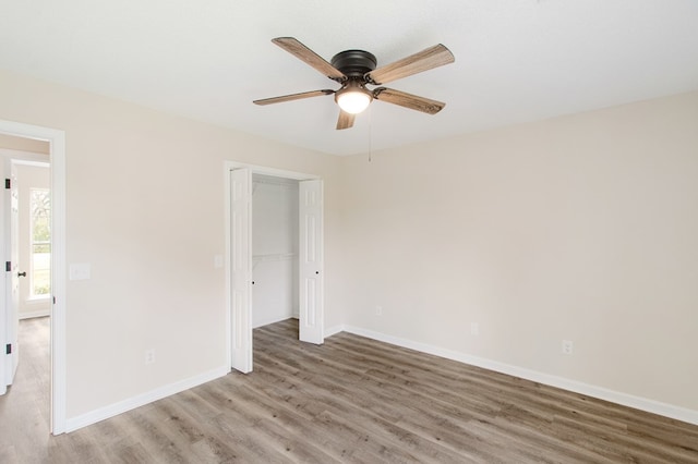 interior space featuring a ceiling fan, baseboards, and wood finished floors