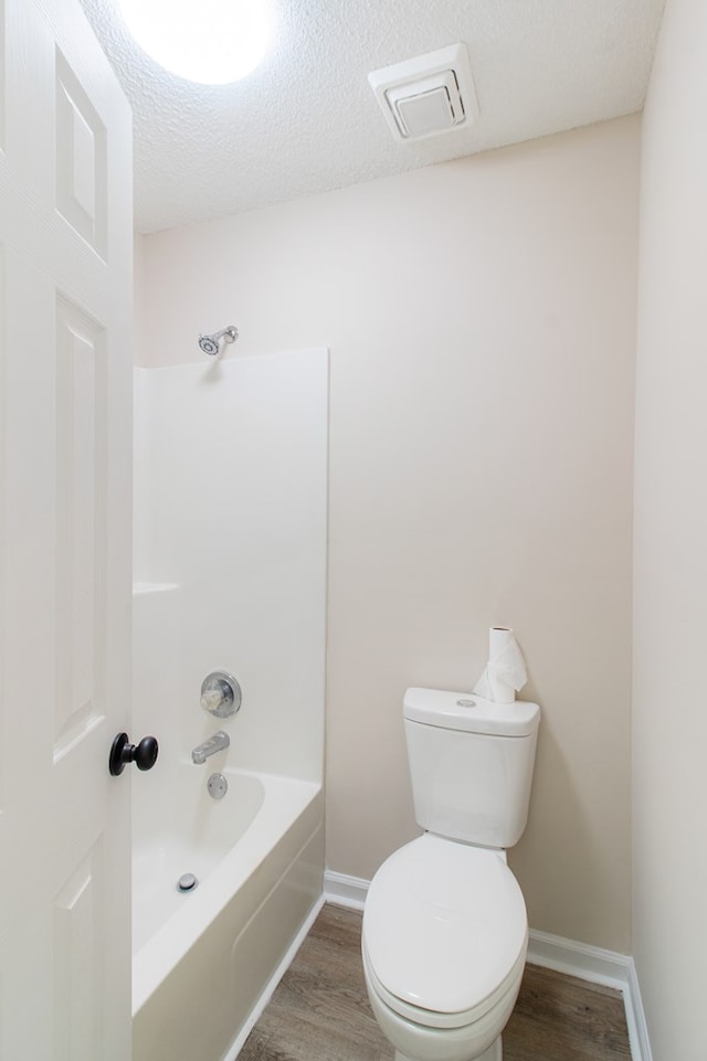 bathroom with visible vents, a textured ceiling, toilet, and wood finished floors