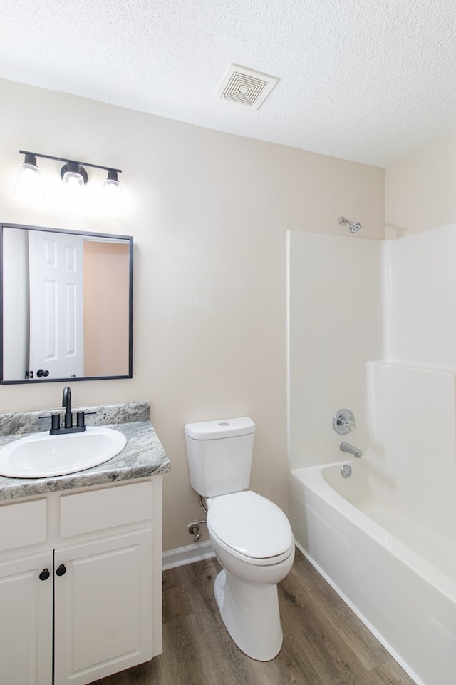 full bathroom with toilet, visible vents, wood finished floors, and vanity