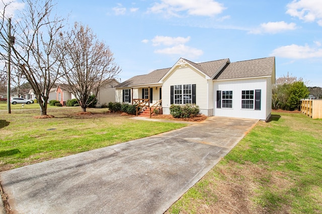 single story home featuring covered porch, a shingled roof, and a front yard