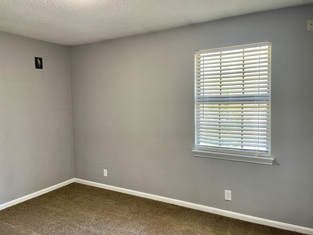 unfurnished room featuring carpet, baseboards, and a textured ceiling