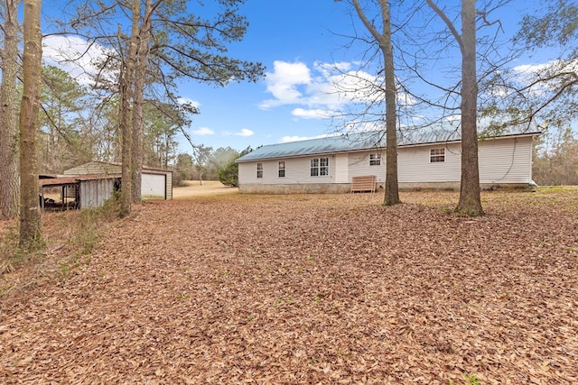 rear view of house featuring a garage and an outdoor structure