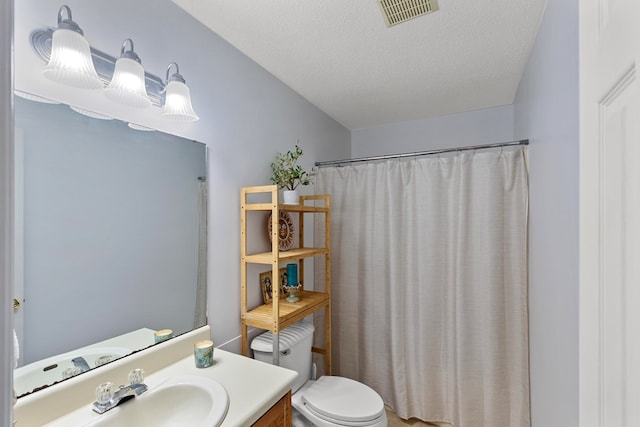 bathroom featuring vanity, curtained shower, toilet, and a textured ceiling