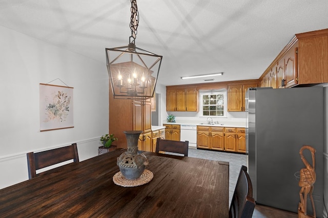 dining room featuring sink, a textured ceiling, and a notable chandelier