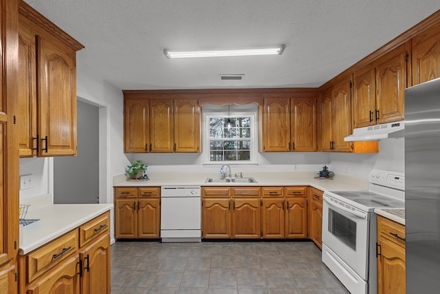 kitchen featuring sink, white appliances, and a textured ceiling