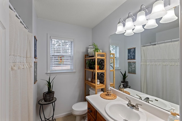 bathroom featuring vanity, a textured ceiling, and toilet